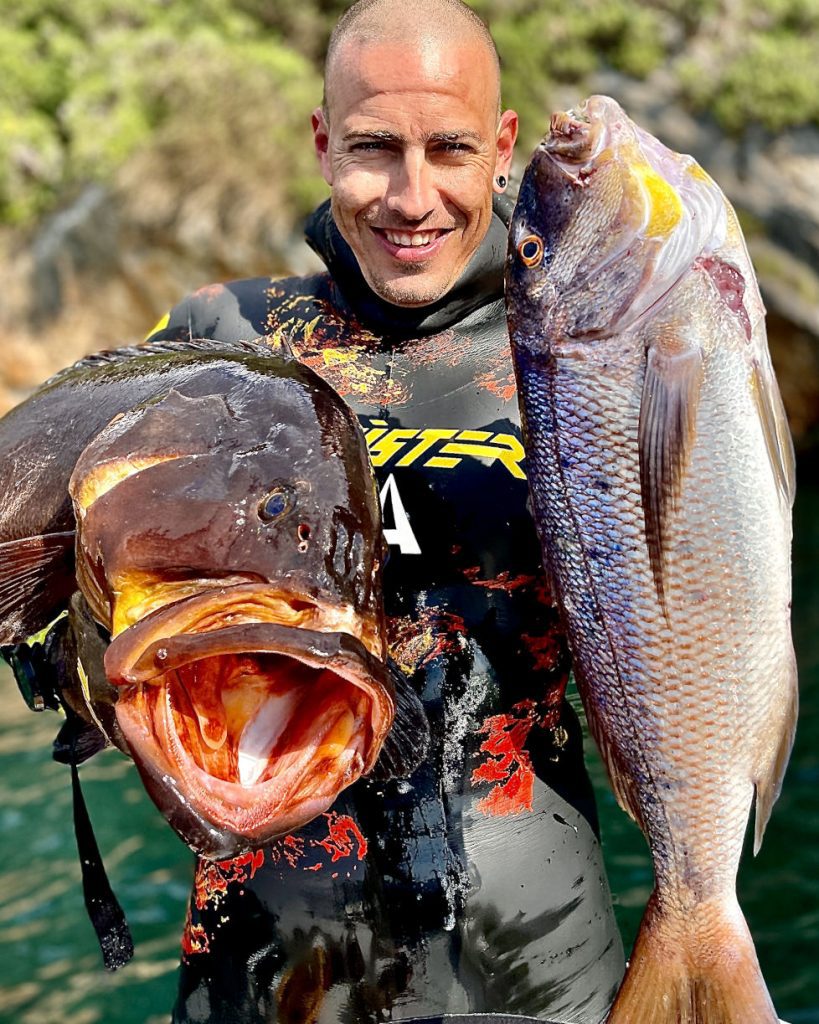Spearfisher Dimos Adamis holding a Dusky Grouper and a Dentex after a successful dive in Greece.